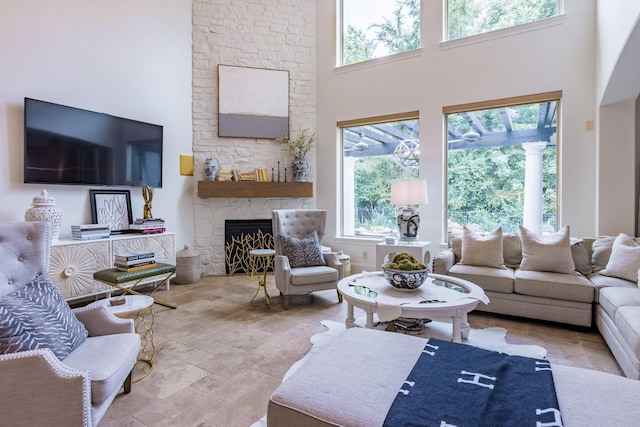 living room with a towering ceiling and a fireplace