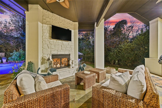 view of patio / terrace with an outdoor stone fireplace and ceiling fan