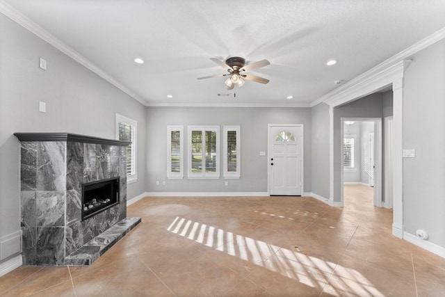 tiled living room featuring a textured ceiling, ceiling fan, a premium fireplace, and crown molding