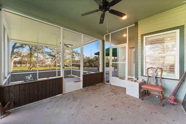 unfurnished sunroom featuring ceiling fan