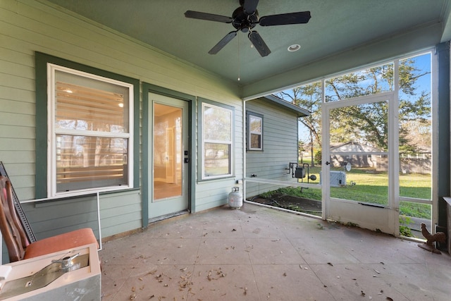 unfurnished sunroom with ceiling fan