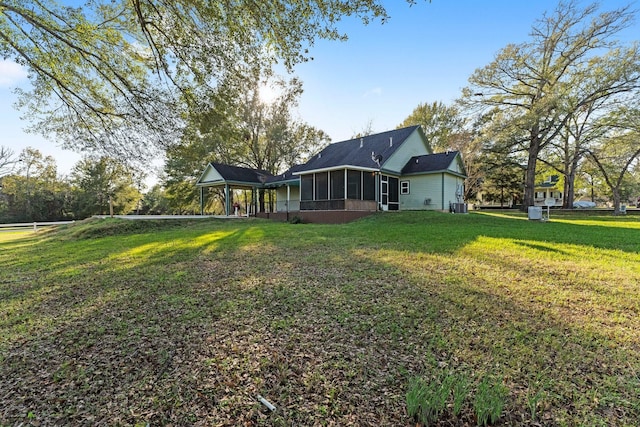 back of property featuring a lawn and a sunroom