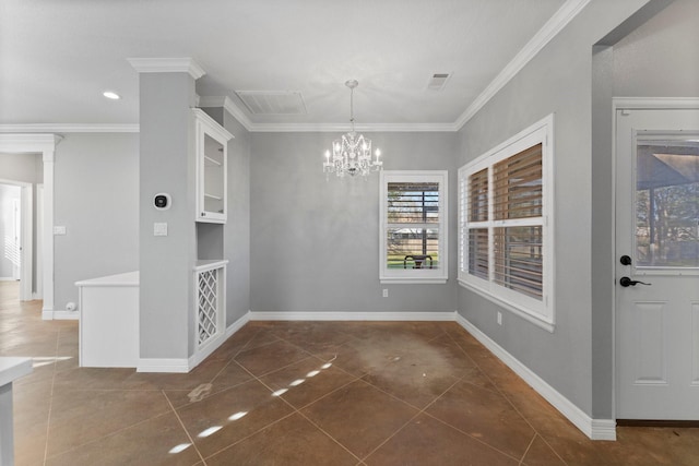 unfurnished dining area with built in shelves, dark tile patterned flooring, crown molding, and a notable chandelier