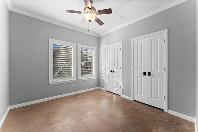 unfurnished bedroom with tile patterned flooring, ceiling fan, crown molding, and multiple closets