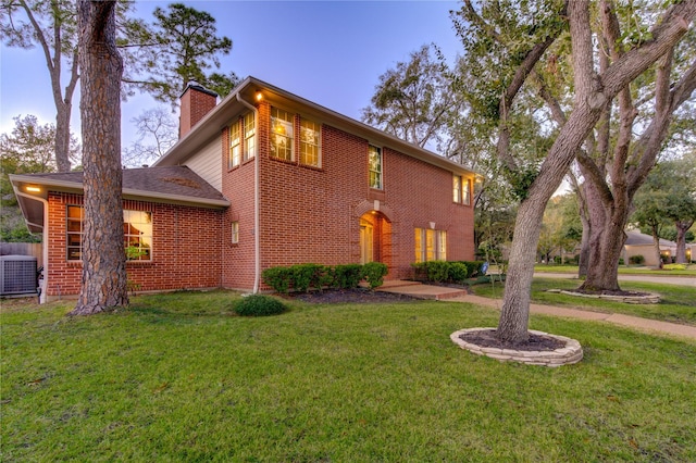 view of front facade with central AC unit and a front yard