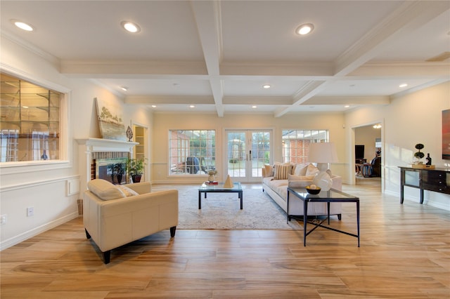 living room featuring french doors, a brick fireplace, built in shelves, beam ceiling, and light hardwood / wood-style flooring