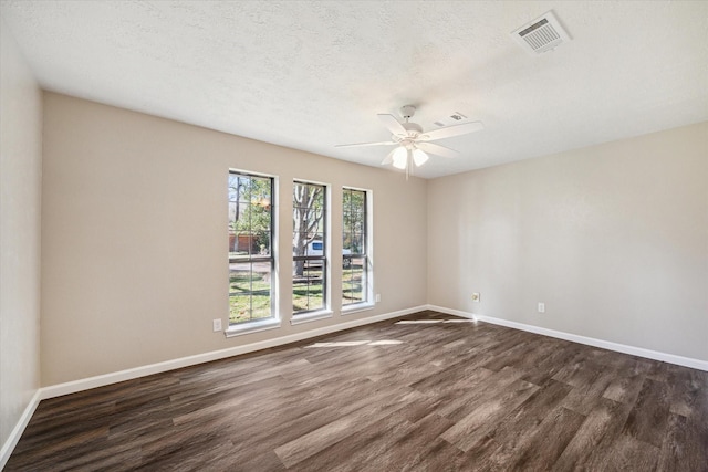 unfurnished room with ceiling fan, dark wood-type flooring, and a textured ceiling