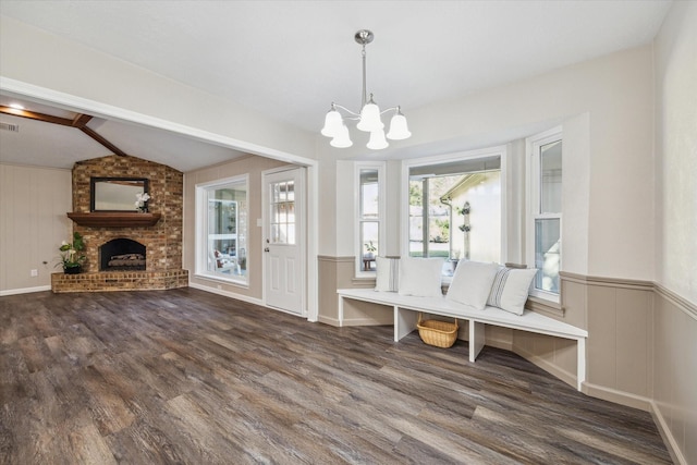 mudroom featuring dark hardwood / wood-style flooring, lofted ceiling, a fireplace, and a chandelier