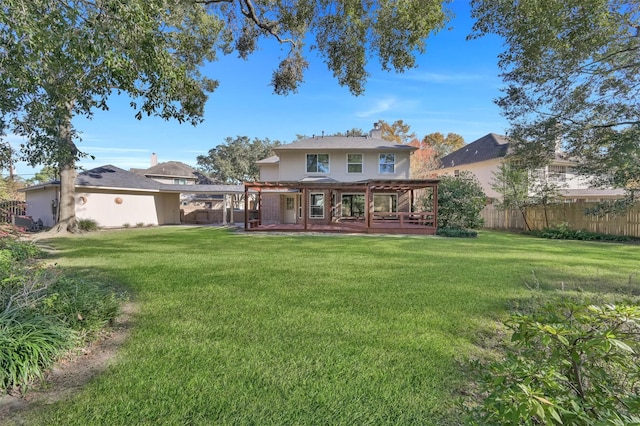 rear view of house with a lawn and a wooden deck