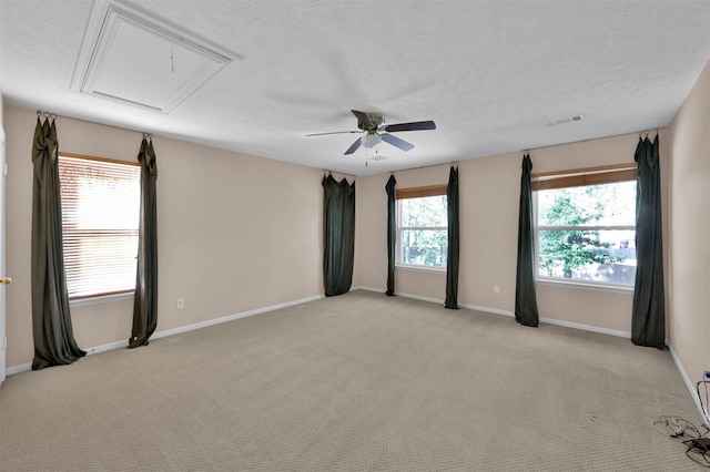 carpeted spare room with ceiling fan and a textured ceiling