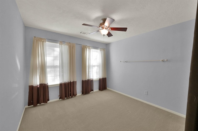 carpeted empty room featuring a textured ceiling and ceiling fan