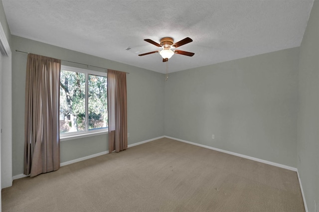 empty room featuring a textured ceiling, ceiling fan, and light carpet