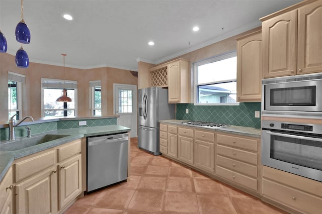 kitchen with light brown cabinets, hanging light fixtures, sink, appliances with stainless steel finishes, and a healthy amount of sunlight