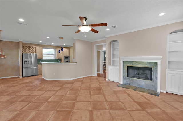 unfurnished living room featuring a fireplace, built in shelves, ceiling fan, and ornamental molding