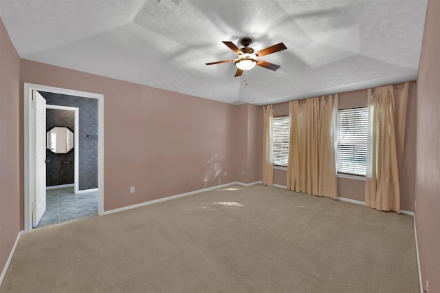 unfurnished room with ceiling fan, light carpet, and a textured ceiling