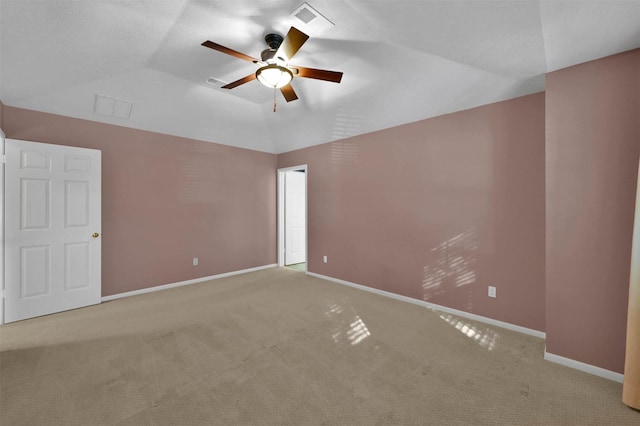 carpeted spare room featuring ceiling fan and vaulted ceiling