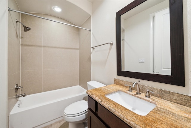 full bathroom featuring vanity, tiled shower / bath combo, and toilet