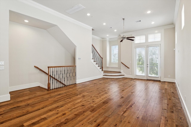 unfurnished living room with ceiling fan, dark hardwood / wood-style flooring, ornamental molding, and french doors