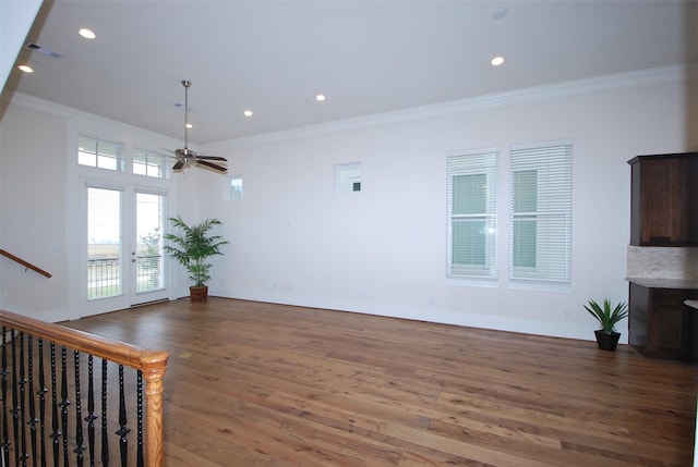 unfurnished living room featuring crown molding, ceiling fan, and dark hardwood / wood-style floors