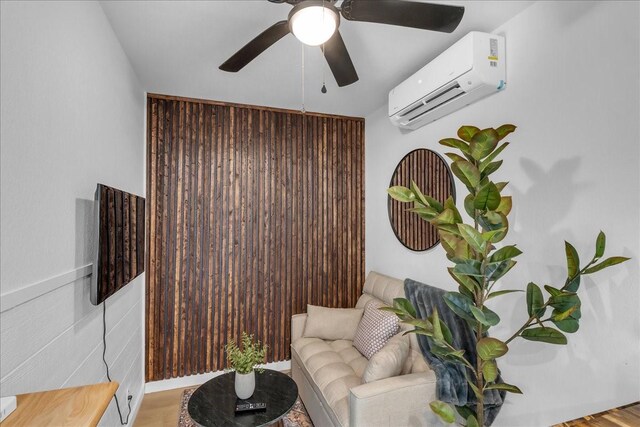 1411 Clay St, Brenham, TX 77833 - living area featuring a wall mounted air conditioner, ceiling fan, and wood finished floors
