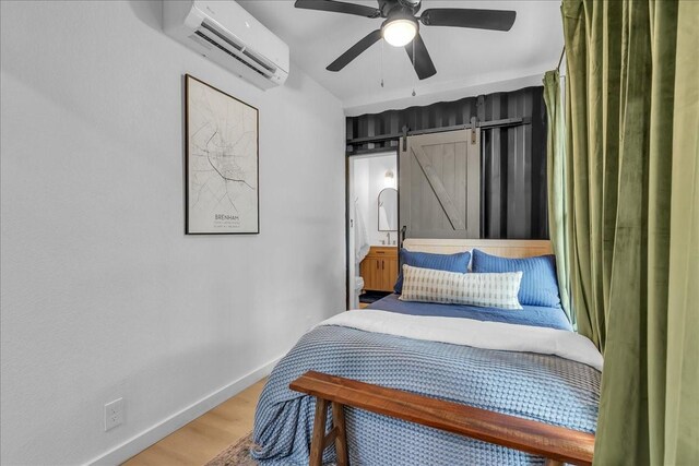 1411 Clay St, Brenham, TX 77833 - bedroom featuring a wall unit AC, light wood-style flooring, and a ceiling fan