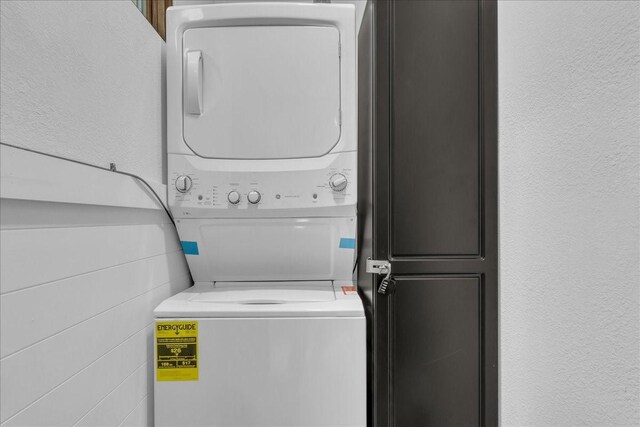 1411 Clay St, Brenham, TX 77833 - laundry room featuring stacked washing machine and dryer and a textured wall