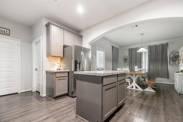 kitchen with gray cabinets, a center island, pendant lighting, dark wood-type flooring, and stainless steel refrigerator with ice dispenser