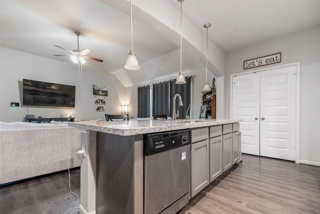 kitchen featuring dishwasher, a kitchen island with sink, sink, decorative light fixtures, and lofted ceiling