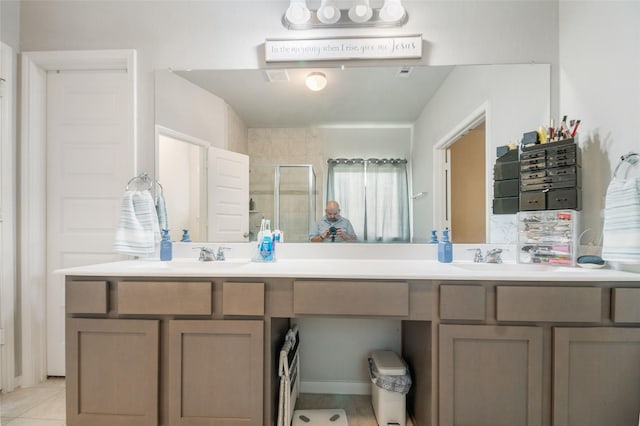 bathroom featuring tile patterned flooring, an enclosed shower, and vanity