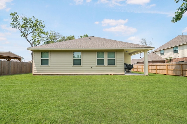 rear view of house featuring a yard and a patio