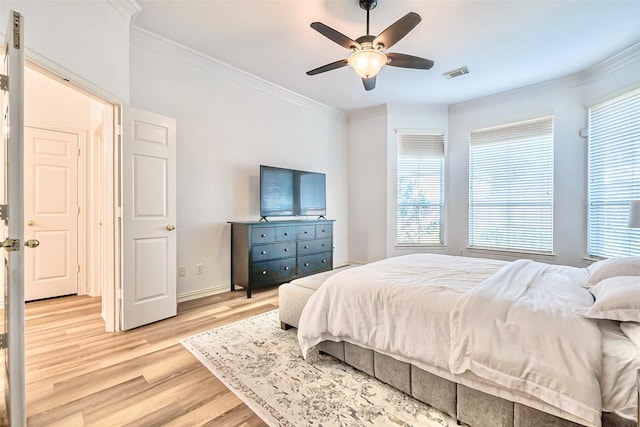 bedroom featuring ceiling fan, light wood-type flooring, and crown molding