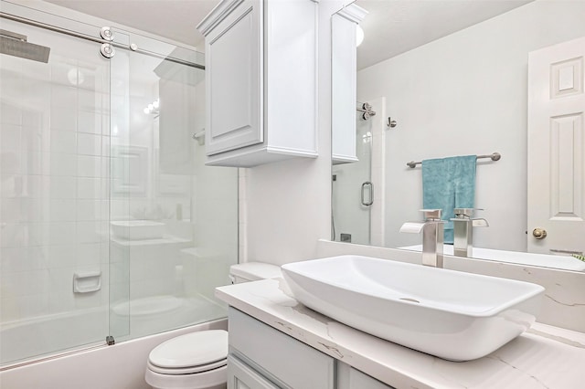 full bathroom featuring combined bath / shower with glass door, vanity, and toilet