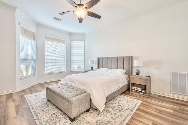 bedroom with ceiling fan, ornamental molding, and light hardwood / wood-style flooring