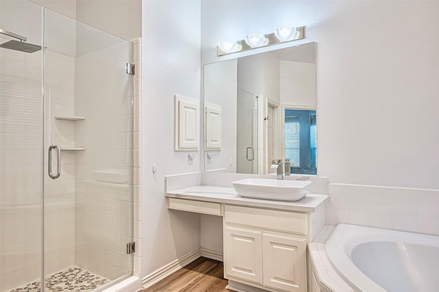 bathroom featuring wood-type flooring, vanity, and shower with separate bathtub