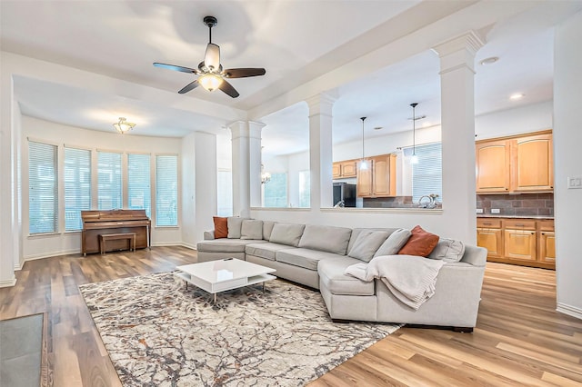 living room with ceiling fan, light hardwood / wood-style floors, and sink