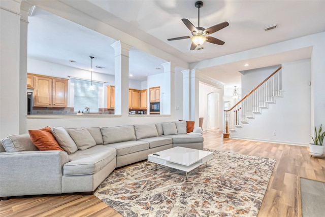 living room with ceiling fan, light hardwood / wood-style floors, and sink