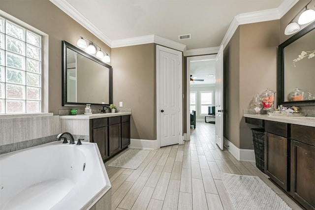 bathroom with vanity, crown molding, and a tub