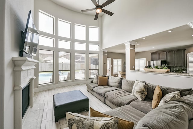 living room featuring a high ceiling, a wealth of natural light, and ceiling fan