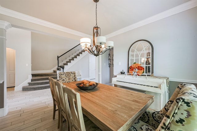 dining space featuring ornamental molding, a chandelier, and light hardwood / wood-style floors