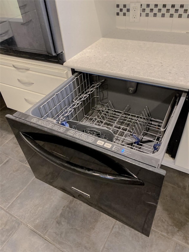 details featuring dishwashing machine and backsplash