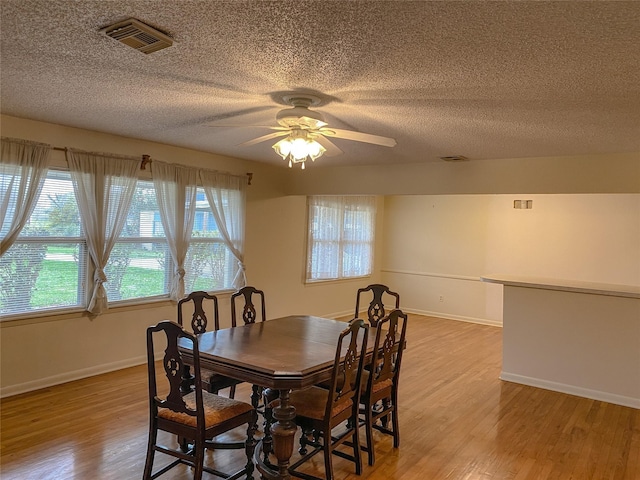 dining space with ceiling fan and light hardwood / wood-style flooring