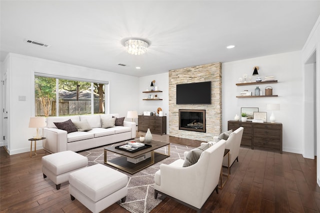 living room featuring a fireplace, dark hardwood / wood-style floors, and an inviting chandelier