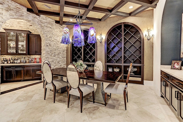 wine room with beamed ceiling, indoor bar, and coffered ceiling