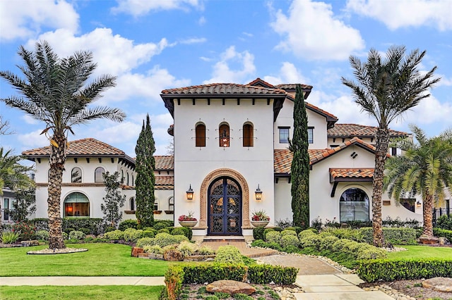 mediterranean / spanish home with french doors and a front lawn