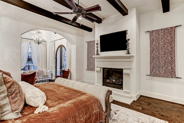 bedroom with beam ceiling, ceiling fan with notable chandelier, and wood-type flooring