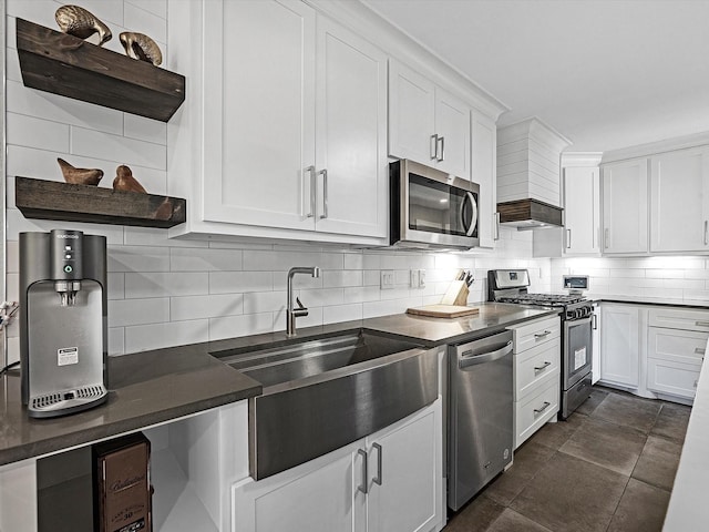 kitchen with white cabinets, decorative backsplash, stainless steel appliances, and sink