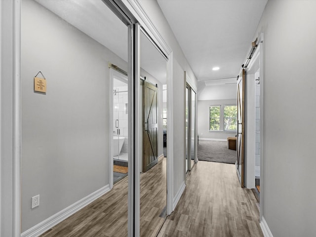 corridor featuring hardwood / wood-style floors and a barn door