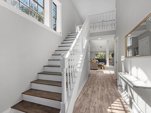 stairs featuring a high ceiling and hardwood / wood-style flooring