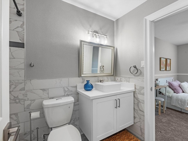 bathroom with vanity, tile walls, and toilet