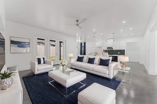 living room with ceiling fan and concrete flooring